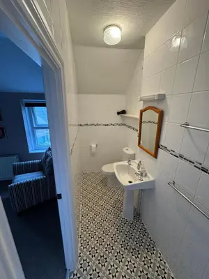 a bathroom with a sink and a mirror at Ashfield Guesthouse in Douglas