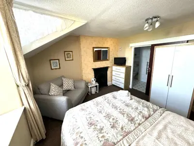 a bedroom with a bed and a couch at Ashfield Guesthouse in Douglas