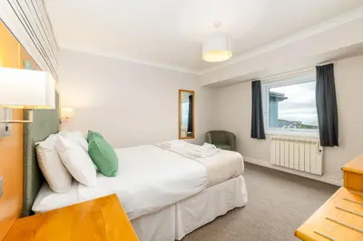 a bedroom with a large white bed and a window at Seacote Hotel in St Bees