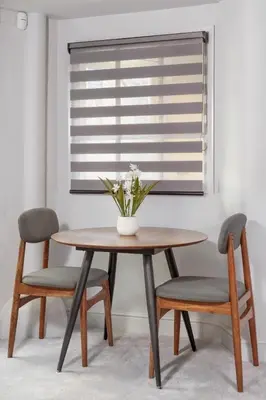 a dining room table with two chairs and a vase with flowers at Keswick Lake Road Apartments in Keswick