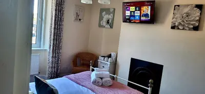 a small bedroom with a bed and a fireplace at Ferndene Guest House in Keswick