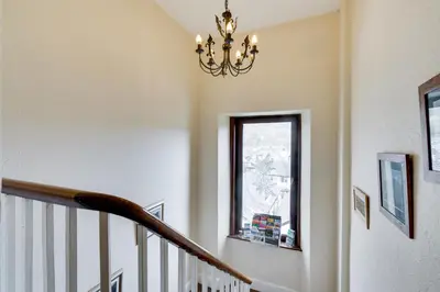 a staircase with a chandelier and a window at Ferndene Guest House in Keswick