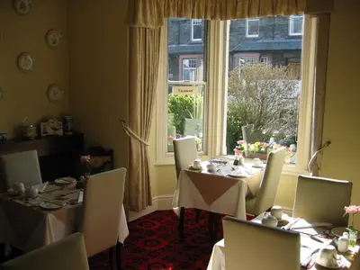 a dining room with tables and chairs and a window at Cragside Guest House in Keswick