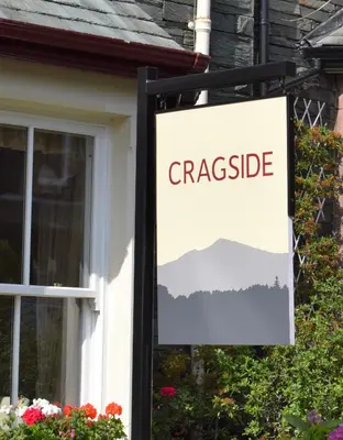 a sign for a cottage in front of a window at Cragside Guest House in Keswick