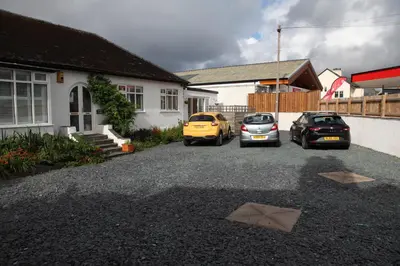 three cars parked in a driveway next to a house at Lynton Lodge Studios in Keswick