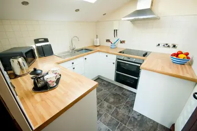 a kitchen with a counter top with a bowl of fruit on it at Graysonside in Cockermouth