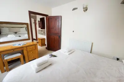 a bedroom with a bed and a desk and a mirror at Graysonside in Cockermouth