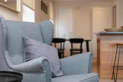 a blue chair with a pillow in a living room at Elliot Suite No7 - Donnini Apartments in Ayr