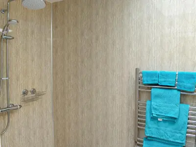 a bathroom with blue towels and a shower at Burnside in Torthorwald