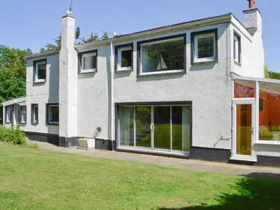 a house with large windows and a lawn at The Old Schoolhouse in Colfin
