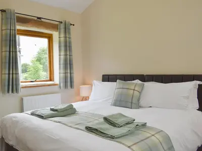 a bedroom with a bed with two towels on it at Wyndham Cottage in Dean