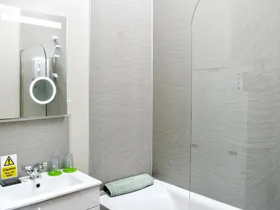 a bathroom with a shower and a toilet and a sink at Wyndham Cottage in Dean