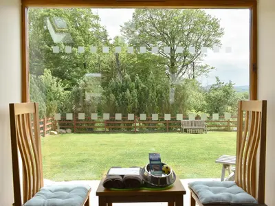 a window view of a yard with a table and chairs at Wyndham Cottage in Dean