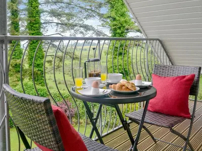 a table with a plate of food on a balcony at The Soup Kitchen in Borgue