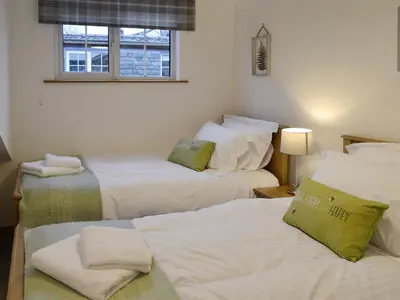 a room with three beds and a window at Clover Cottage in Keswick