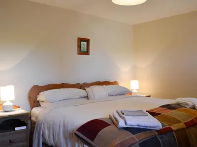 a bedroom with a large bed with two towels on it at Owls Retreat in Whitehaven