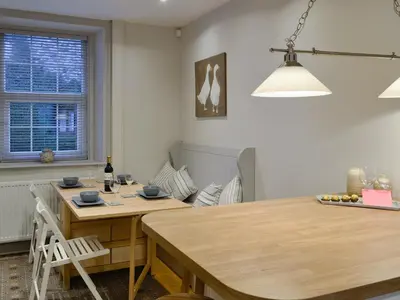 a kitchen with a wooden table and a dining room at Riverholme in Bassenthwaite