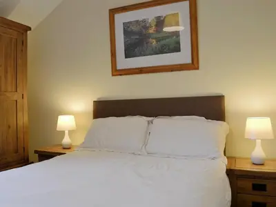 a bedroom with a white bed with two lamps at Lake Road Heights in Keswick