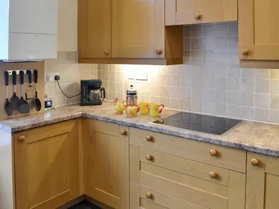 a kitchen with wooden cabinets and a counter top at Lake Road Heights in Keswick