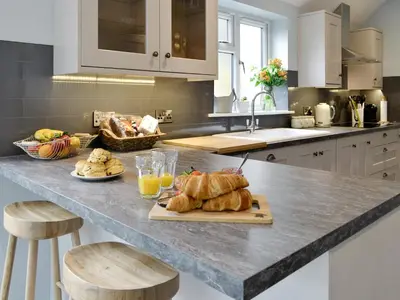 a kitchen with a counter with bread and croissants at Buckle House in Gatehouse of Fleet