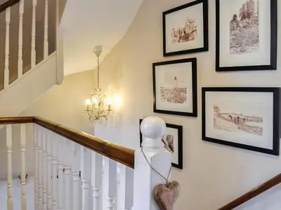 a stairway with framed pictures on the wall at River View in Dumfries