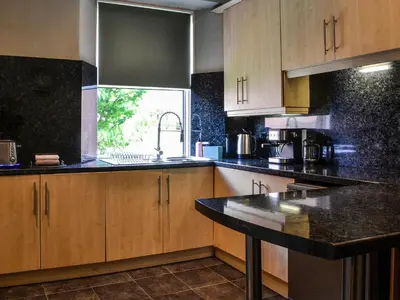 a kitchen with wooden cabinets and a black counter top at River View in Dumfries