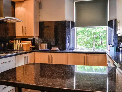 a kitchen with marble counter tops and a sink at River View in Dumfries