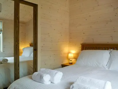 two beds in a room with wooden walls at Bransty in Keswick