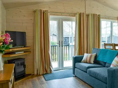 a living room with a blue couch and a television at Bransty in Keswick