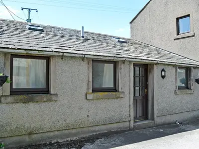 an old brick house with windows and a door at Swallows Return in Whitehaven