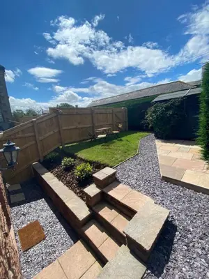 a backyard with a wooden fence and a bench at The Bothey in Brampton