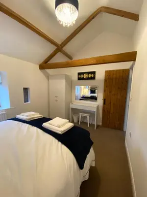 a bedroom with two beds and a desk in it at The Bothey in Brampton