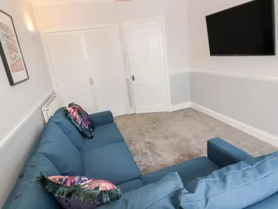 a living room with a blue couch and a flat screen tv at Ivy Bank in Thornhill