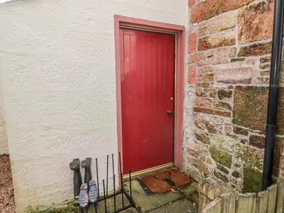 a red door in a brick building with shoes next to it at Ivy Bank in Thornhill