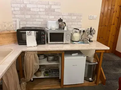 a kitchen with a counter with a microwave and a sink at Stybeck Farm in Thirlmere