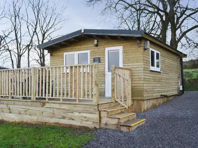 a wooden cabin with a porch and a fence at Robin's Lodge in Westward