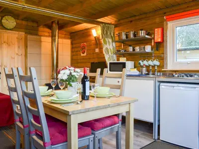 a kitchen with a wooden table with chairs and a tableablish at Robin's Lodge in Westward