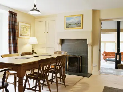 a living room with a table and a fireplace at High Birch Close in Patterdale