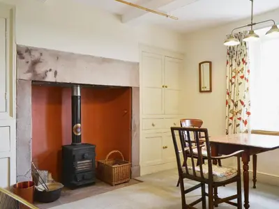 a living room with a wood stove and a table at High Birch Close in Patterdale