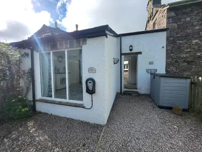 a white house with a window and a pay phone at Juniper HAYLOFT Grasmere in Ambleside