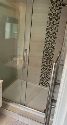 a shower with a glass door in a bathroom at DOVENBY SHIP in Tallentire