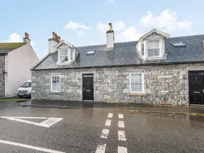a stone house with a car parked in front of it at Killantrae Burn in Port William