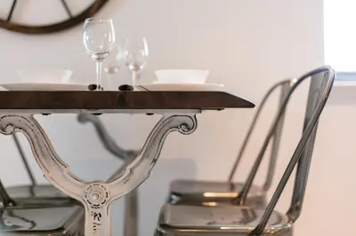 a table with two wine glasses and two chairs at Granary Suite No22 - Donnini Apartments in Ayr