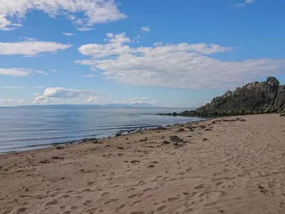 a sandy beach with a view of the ocean at Meadowbank in Girvan