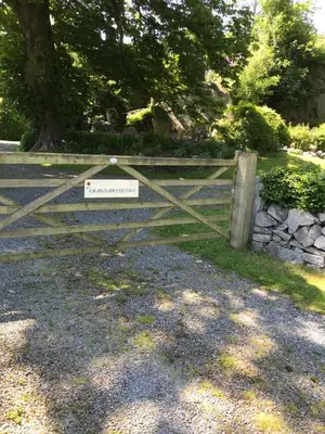 a wooden gate with a sign on it at Craignair Cottage in Dalbeattie