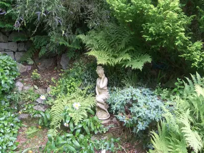 a statue of a woman sitting in a garden at Craignair Cottage in Dalbeattie
