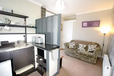 a living room with a sink and a couch at Craignair Cottage in Dalbeattie