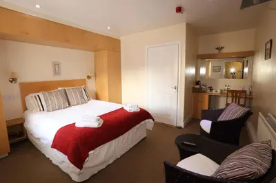 a hotel room with a bed and two chairs at Star Hotel in Kirkcudbright