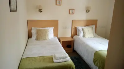 two beds in a small room withskirts at Star Hotel in Kirkcudbright