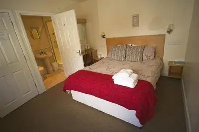 a bedroom with a large bed with towels on it at Star Hotel in Kirkcudbright